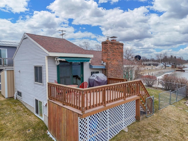 back of property with roof with shingles, fence, a gate, a yard, and a chimney