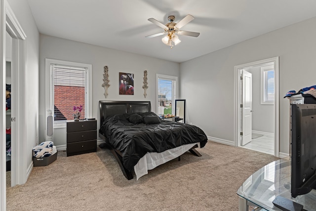 carpeted bedroom with baseboards, ceiling fan, and ensuite bathroom