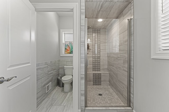 bathroom featuring visible vents, toilet, tile walls, recessed lighting, and a stall shower