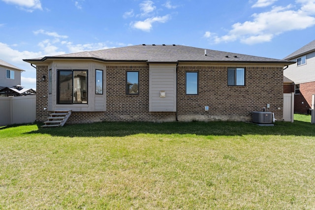 back of house featuring fence, a lawn, central AC, and brick siding
