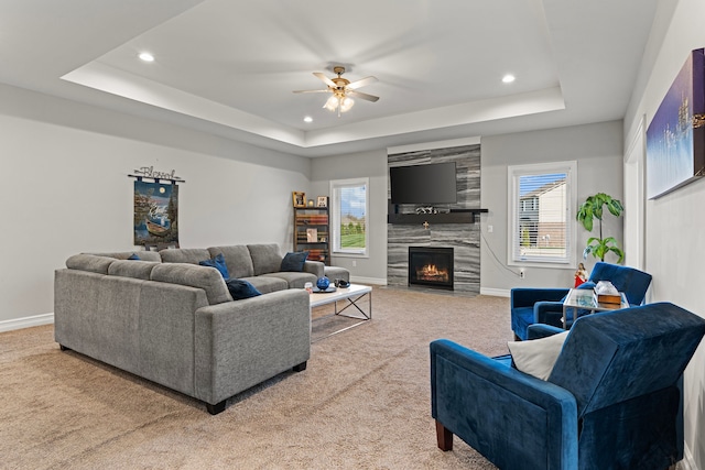 carpeted living area with recessed lighting, a raised ceiling, and a wealth of natural light
