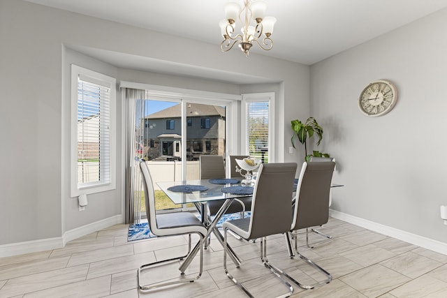dining room with baseboards and a notable chandelier