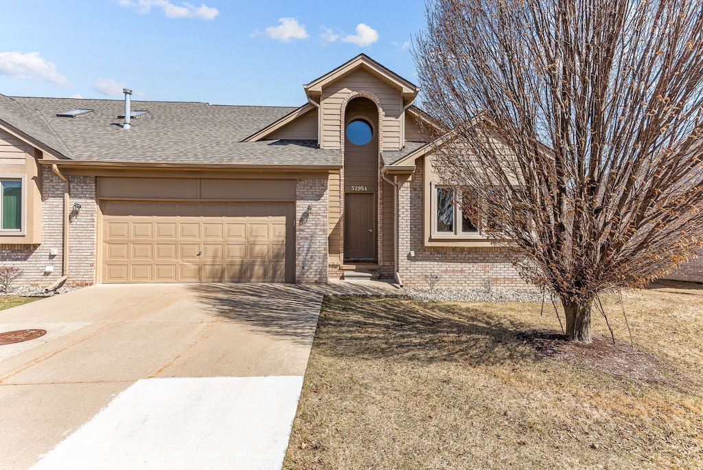 32954 Whispering Ln, Chesterfield, MI 48047 - view of front of property featuring brick siding, driveway, roof with shingles, and an attached garage