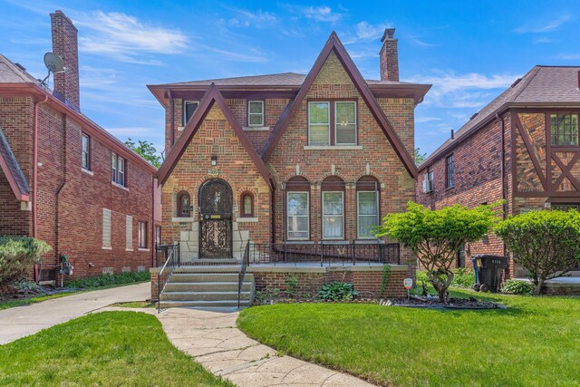8735 Marygrove Dr, Detroit, MI 48221 - tudor home with brick siding, a front lawn, and a chimney