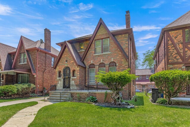8735 Marygrove Dr, Detroit, MI 48221 - tudor house with a chimney, a front yard, and brick siding