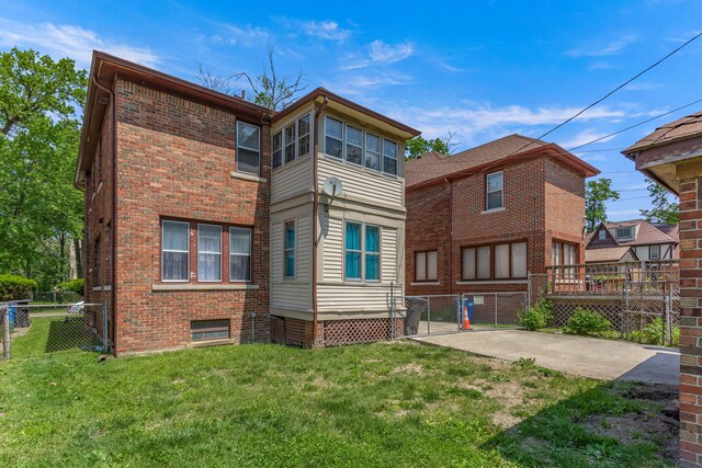 8735 Marygrove Dr, Detroit, MI 48221 - back of house featuring brick siding, a gate, fence, and a lawn