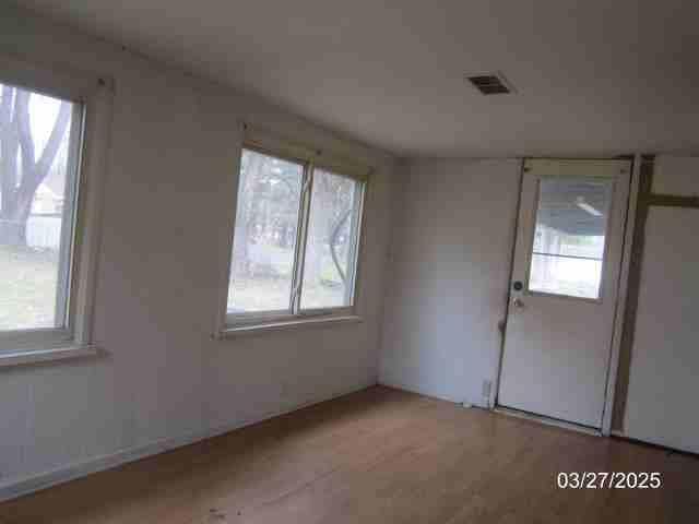 unfurnished room featuring visible vents