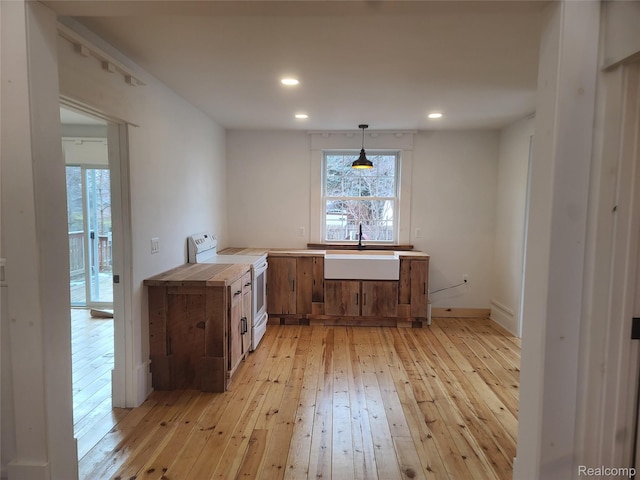 3685 Main St, Akron, MI 48701 - kitchen with white electric range, a sink, light wood finished floors, plenty of natural light, and recessed lighting