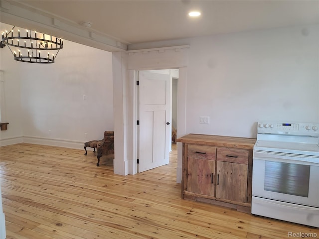 3685 Main St, Akron, MI 48701 - kitchen with white electric stove, a chandelier, light wood-style floors, baseboards, and recessed lighting