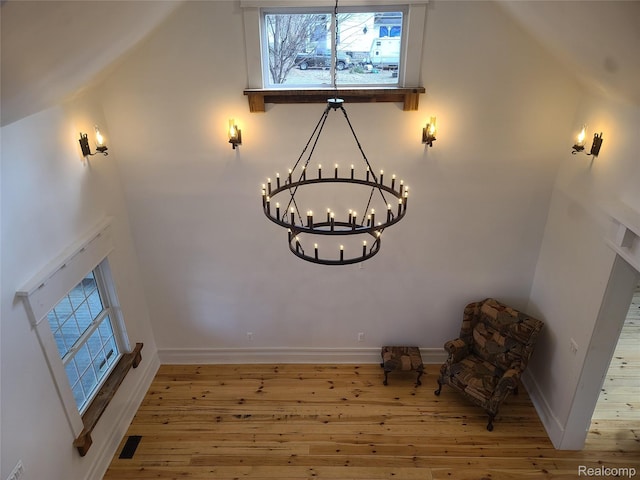3685 Main St, Akron, MI 48701 - unfurnished room featuring a chandelier, hardwood / wood-style floors, plenty of natural light, and baseboards
