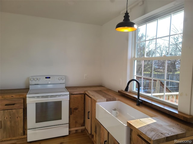 3685 Main St, Akron, MI 48701 - kitchen with electric range, a sink, plenty of natural light, and brown cabinetry