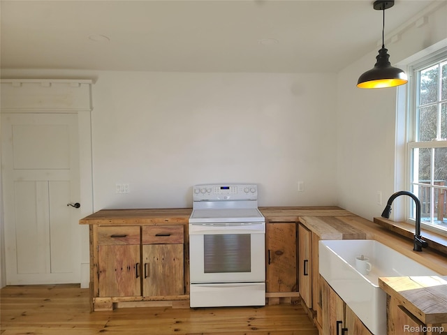 3685 Main St, Akron, MI 48701 - kitchen with white range with electric cooktop, a sink, brown cabinetry, and light wood-style floors