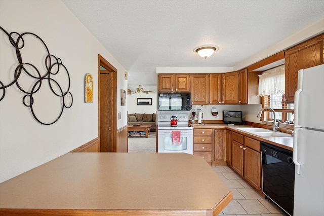 kitchen featuring light countertops, a sink, black appliances, brown cabinetry, and light tile patterned floors