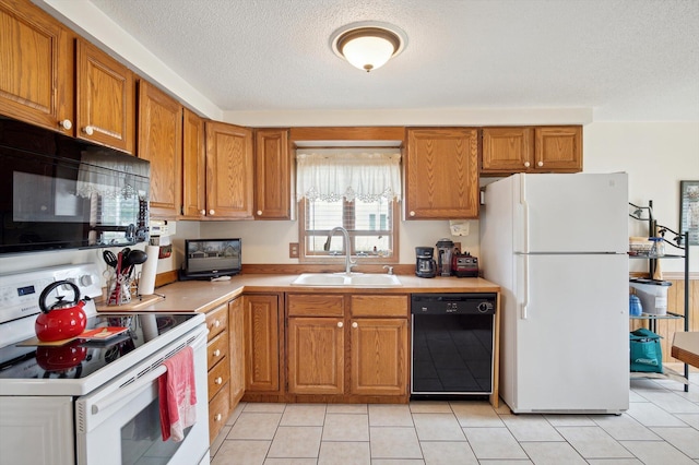 kitchen with a sink, light countertops, black appliances, and brown cabinetry