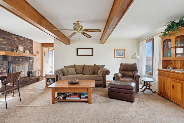 living area with carpet flooring, ceiling fan, and beamed ceiling