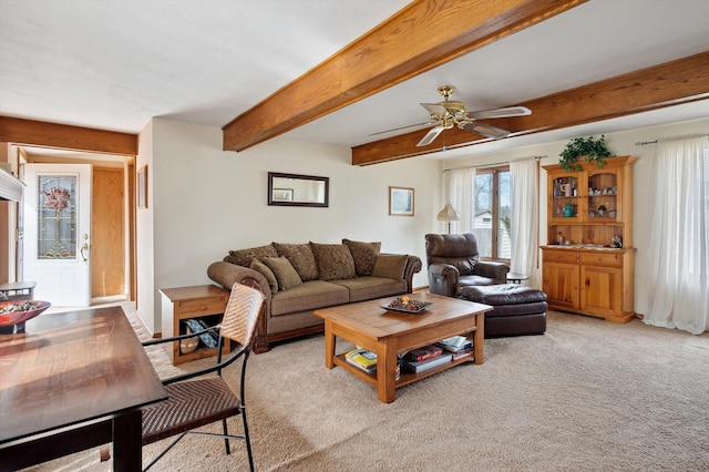 living area featuring ceiling fan, beam ceiling, and light carpet