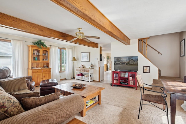 living area with light carpet, beam ceiling, stairs, and ceiling fan