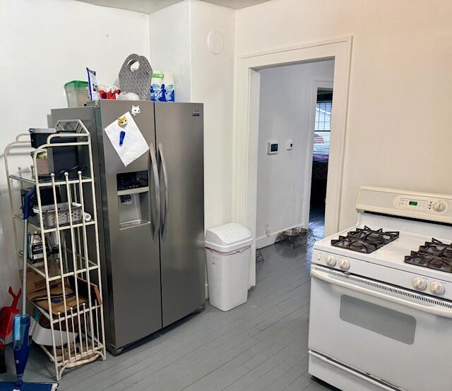 1024 Madison St, Muskegon, MI 49442 - kitchen with stainless steel fridge with ice dispenser, white range with gas stovetop, and wood finished floors