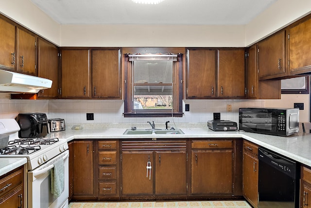 kitchen with under cabinet range hood, a sink, black appliances, and decorative backsplash