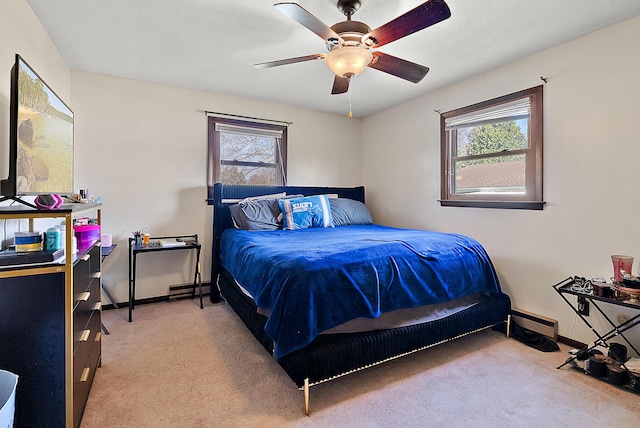 carpeted bedroom with a ceiling fan and baseboards