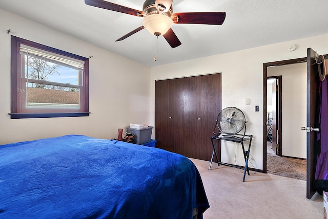 bedroom featuring light carpet, baseboards, a closet, and a ceiling fan