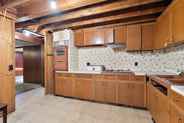 kitchen with light countertops, a warming drawer, white cooktop, wall oven, and light floors