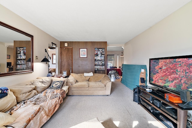 living area featuring wood walls and carpet floors