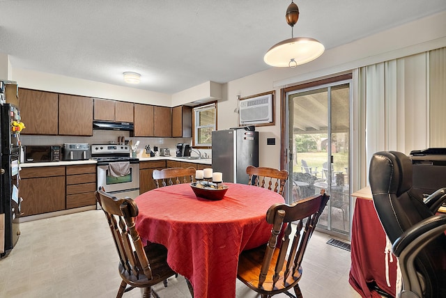 dining space featuring visible vents, a wall unit AC, and light floors