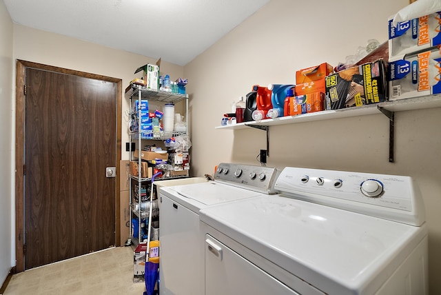 clothes washing area with washing machine and dryer, laundry area, and light floors