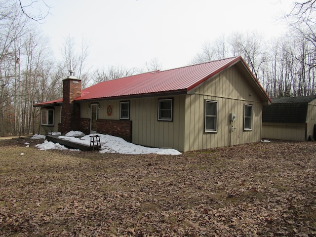 view of property exterior with metal roof and a chimney