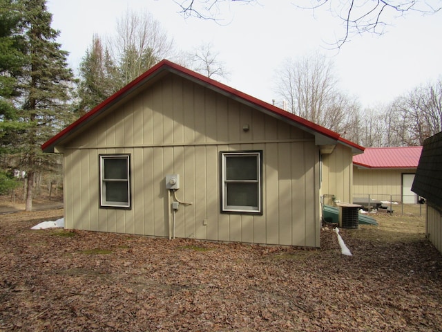 view of side of property featuring central AC unit and fence