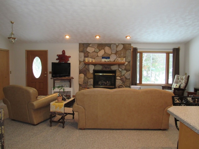 living area featuring a textured ceiling, a fireplace, and light colored carpet