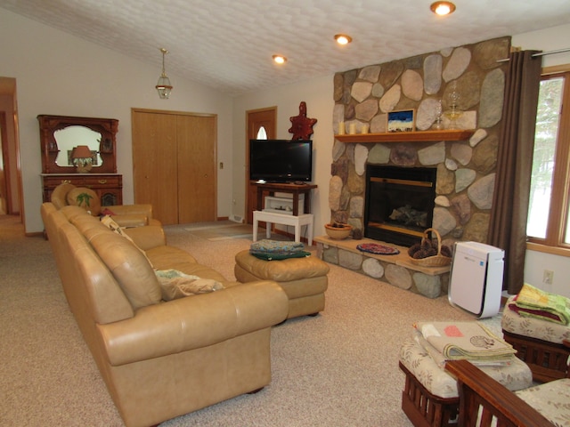 living room with a stone fireplace, lofted ceiling, carpet flooring, and a textured ceiling