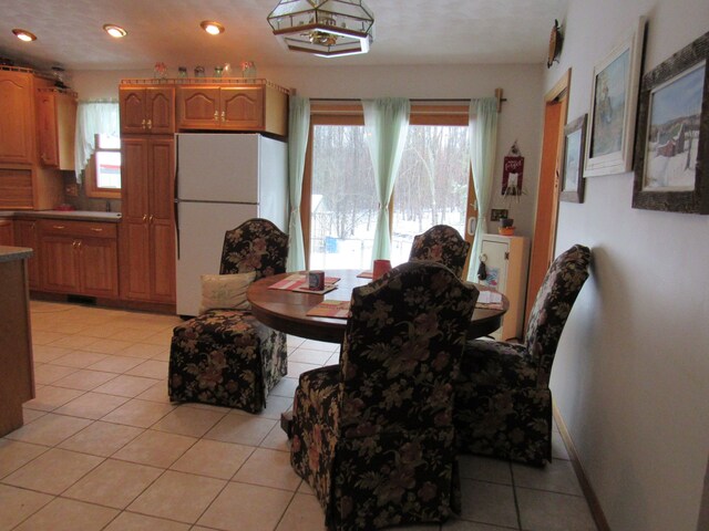 dining space with plenty of natural light, baseboards, light tile patterned flooring, and recessed lighting