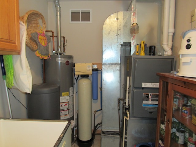 utility room featuring gas water heater and visible vents