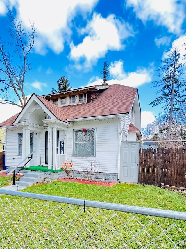 1702 Copeman Blvd, Flint, MI 48504 - bungalow featuring roof with shingles, a fenced front yard, and a front yard