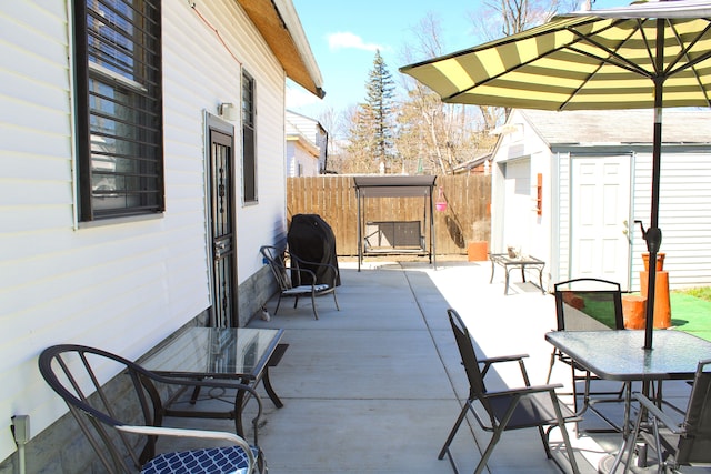 1702 Copeman Blvd, Flint, MI 48504 - view of patio featuring an outdoor structure, fence, outdoor dining space, and a shed