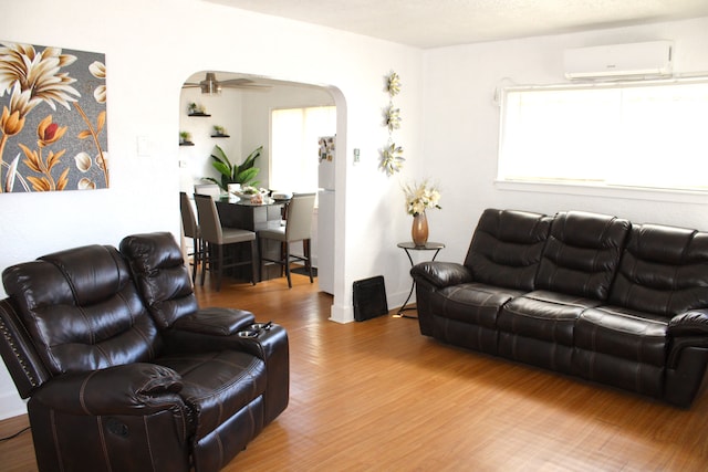 1702 Copeman Blvd, Flint, MI 48504 - living area featuring arched walkways, a wall mounted air conditioner, and wood finished floors