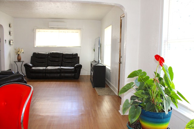 1702 Copeman Blvd, Flint, MI 48504 - living room with arched walkways, a wall unit AC, and wood finished floors