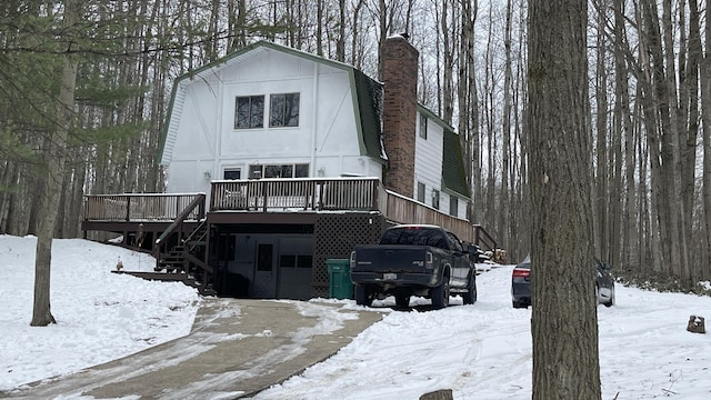 12181 Trail Creek Dr, Stanwood, MI 49346 - view of front of home featuring a chimney, a gambrel roof, a wooden deck, and stairway