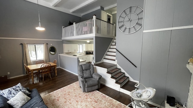 12181 Trail Creek Dr, Stanwood, MI 49346 - living room with dark wood-style floors, beamed ceiling, a high ceiling, and stairway