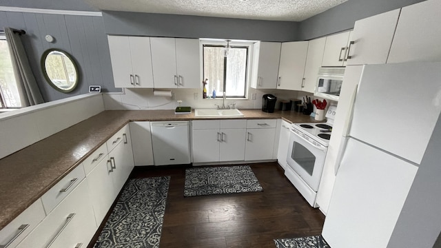 12181 Trail Creek Dr, Stanwood, MI 49346 - kitchen featuring white appliances, dark wood-style flooring, a textured ceiling, a sink, and white cabinets