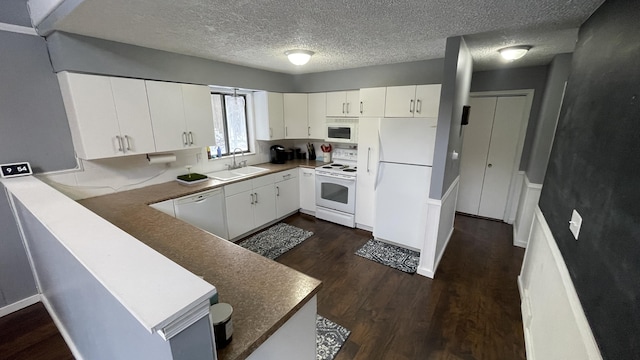 12181 Trail Creek Dr, Stanwood, MI 49346 - kitchen with a sink, white cabinetry, a peninsula, dark wood-style floors, and white appliances