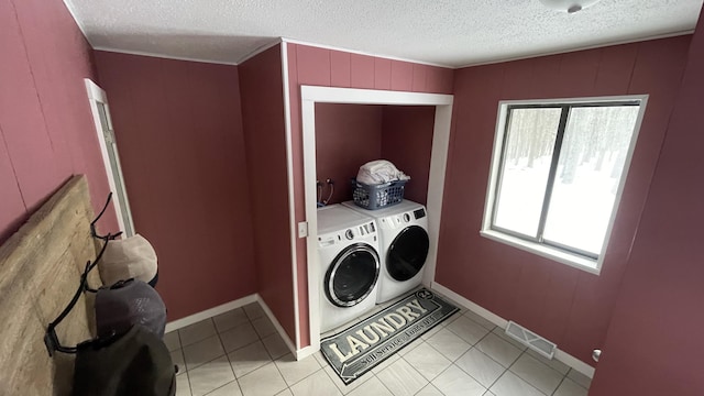 12181 Trail Creek Dr, Stanwood, MI 49346 - clothes washing area featuring washing machine and clothes dryer, visible vents, light tile patterned floors, and plenty of natural light