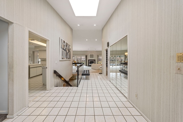hallway with light tile patterned flooring and wallpapered walls