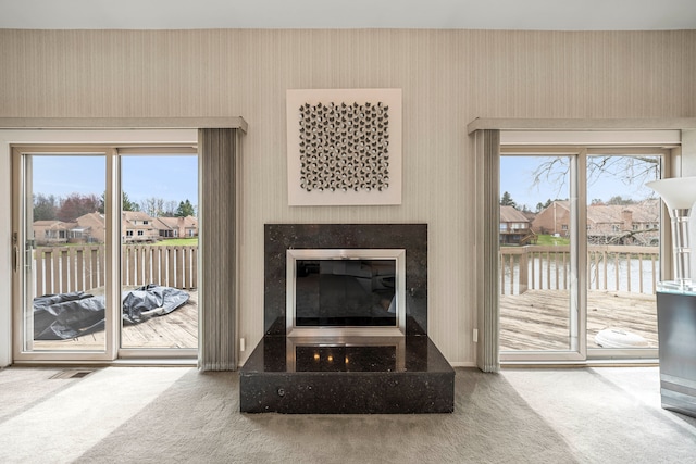 living room featuring wallpapered walls, carpet floors, and a healthy amount of sunlight