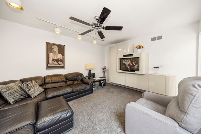 living room featuring rail lighting, dark carpet, ceiling fan, and visible vents