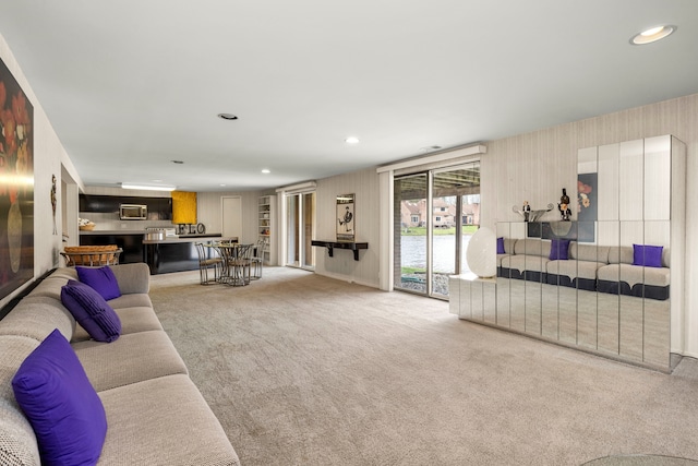 carpeted living room featuring recessed lighting and indoor bar