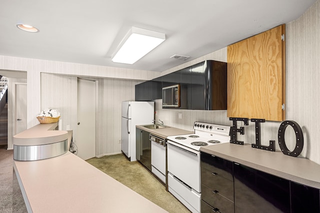 kitchen featuring light colored carpet, light countertops, a sink, white appliances, and visible vents