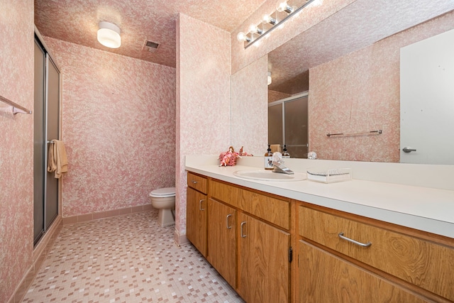 full bathroom with vanity, toilet, wallpapered walls, a stall shower, and visible vents